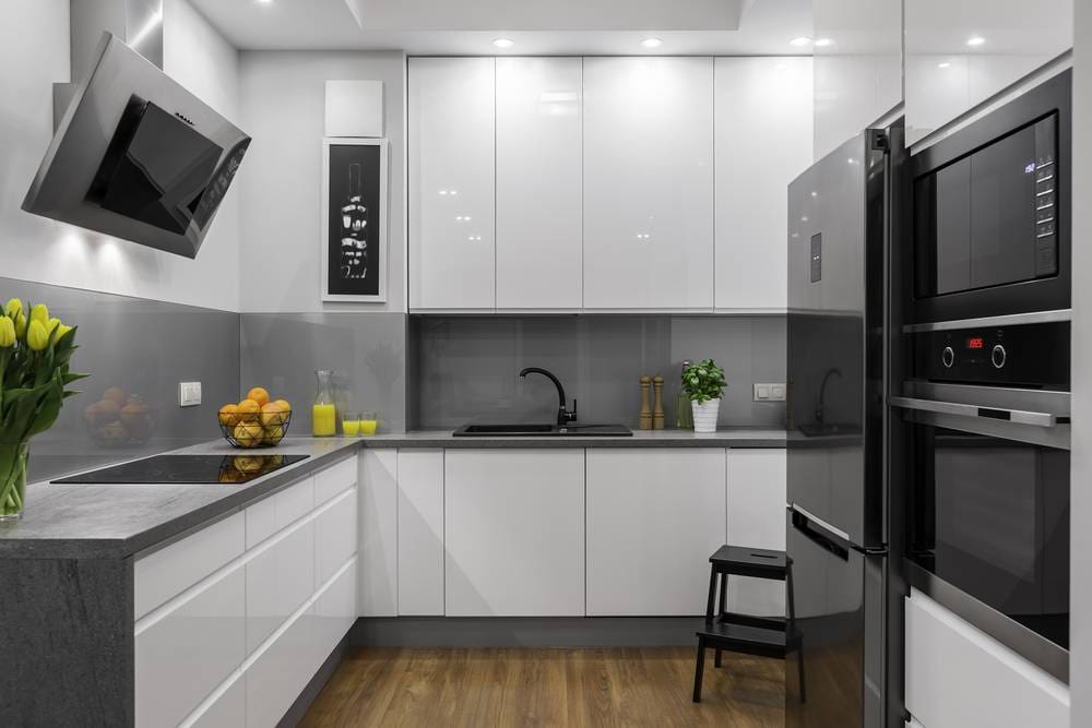 A gorgeous interior designer’s mock-up of a luxury, modern kitchen with an over-the-range microwave recessed and built in right above a compact, modern oven.