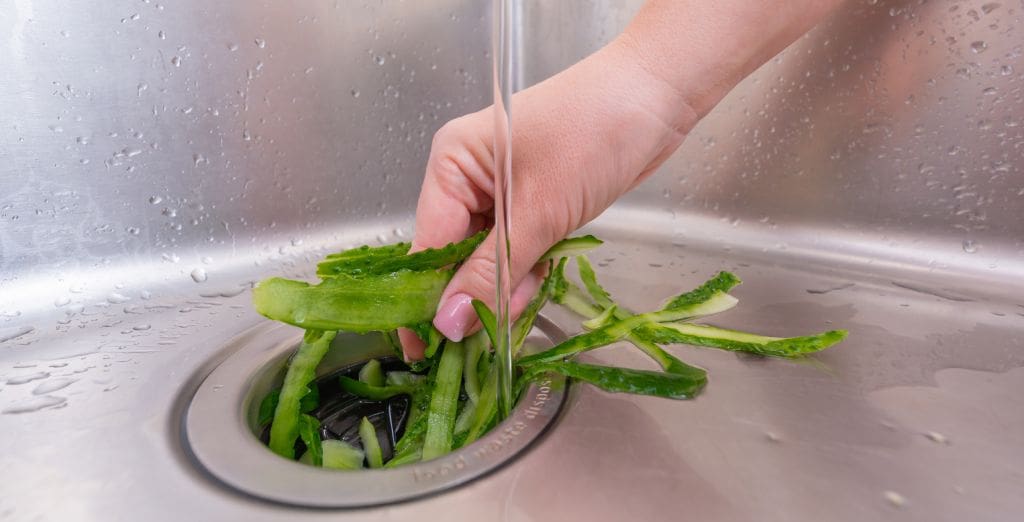 A woman enjoys her new unit, after following XO’s tips on how to replace a garbage disposal.