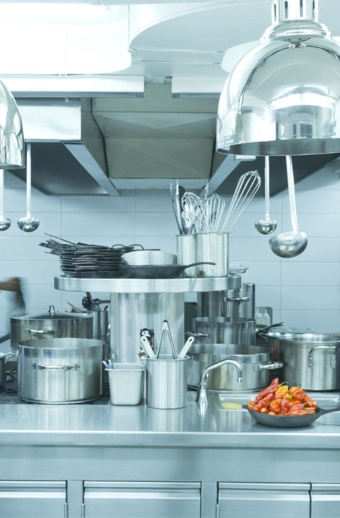 Professional kitchen with stainless steel kitchen appliances, cookware, and countertops